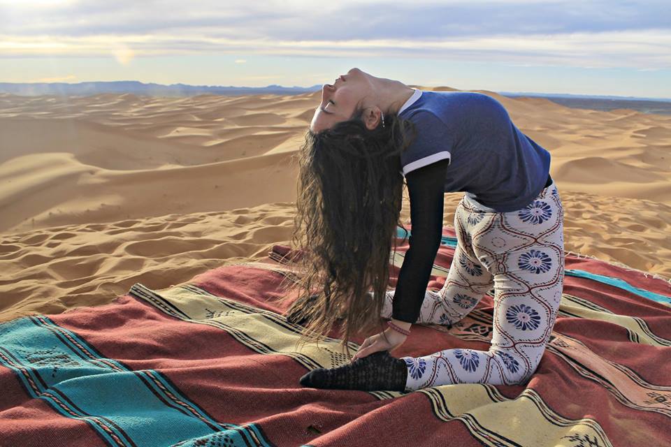 woman in blue leggings and black tank top doing yoga