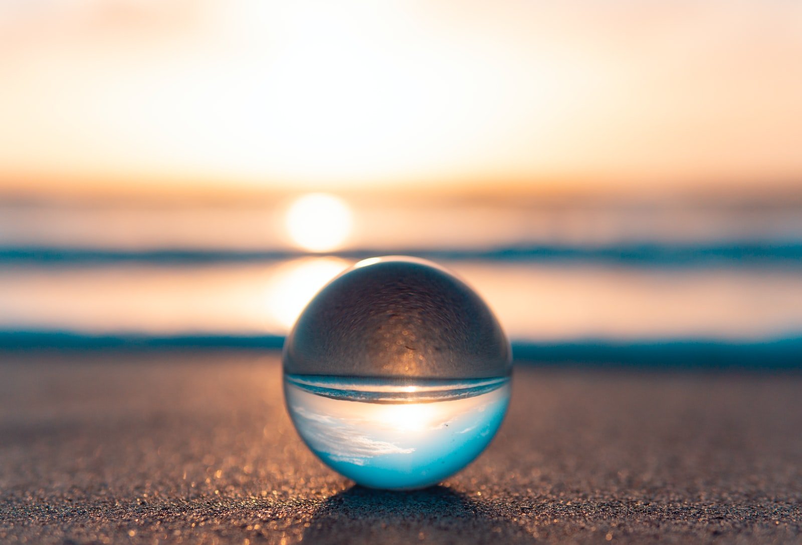 Photo by Joshua Woroniecki blue and silver ball on black sand