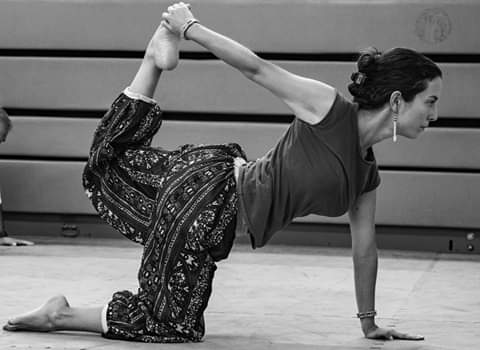 woman in blue leggings and black tank top doing yoga