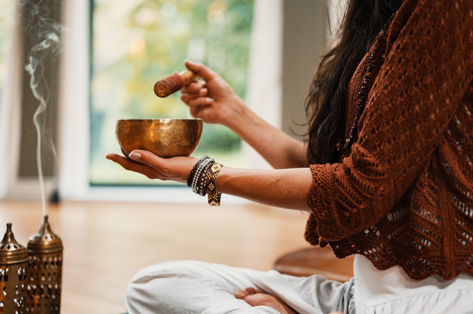 Photo by Conscious Design woman in brown knit sweater holding brown ceramic cup